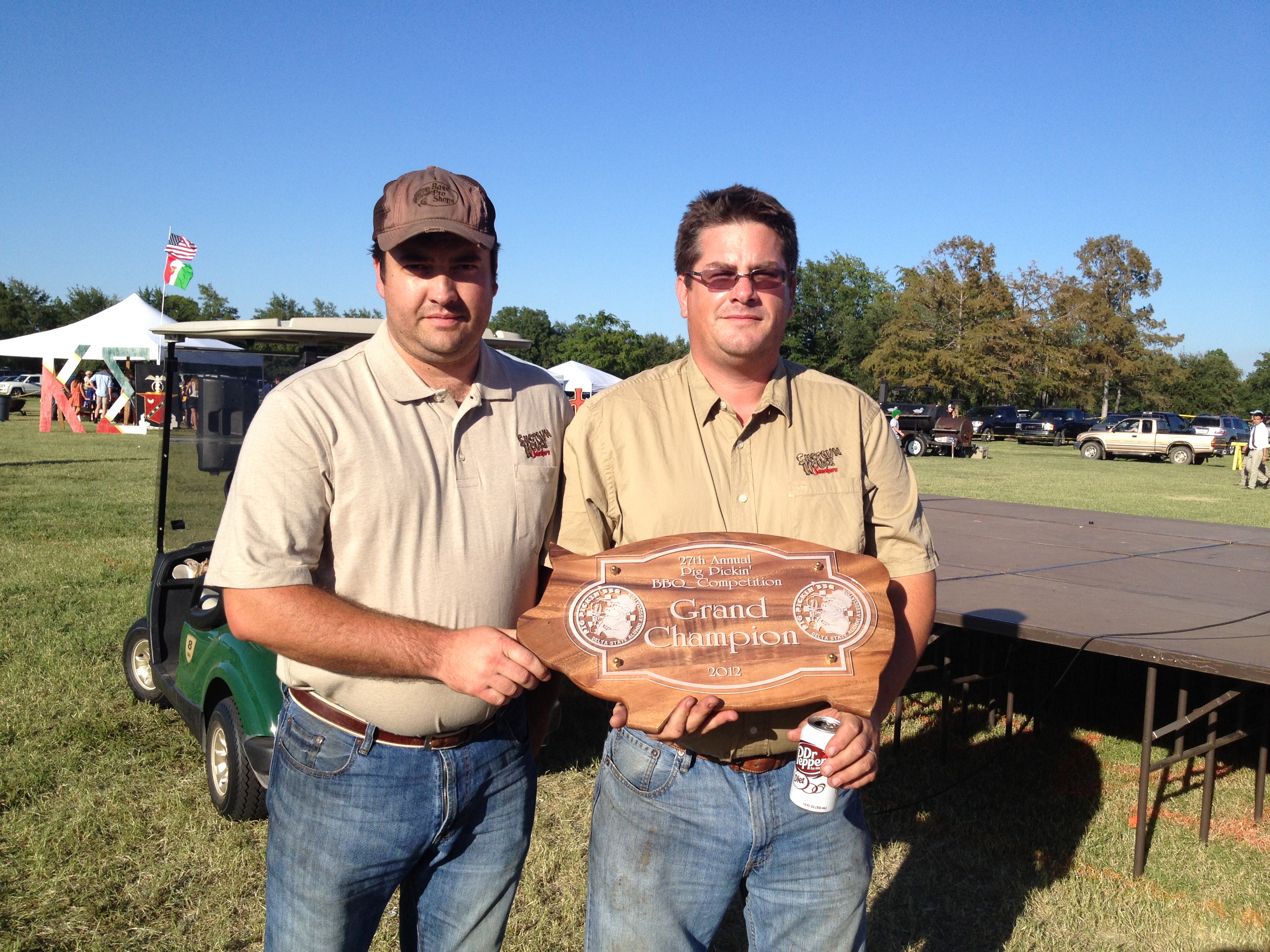 2012 Pig Pickin’ Grand Champions:  From left, Kelvin Sumner of Merigold, and Tony Jones of Cleveland, with the plaque awarded to the 2012 Pig Pickin’ Grand Champion - Shotgun House Smokers.